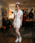 Woman wearing a white nurse costume dress with headband and stethoscope